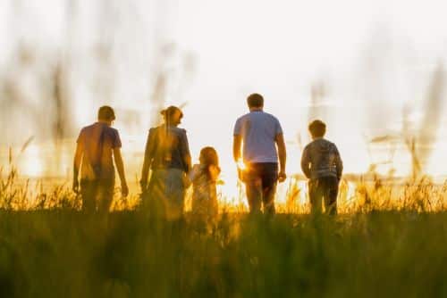 blended family walking in field - parenting time concept