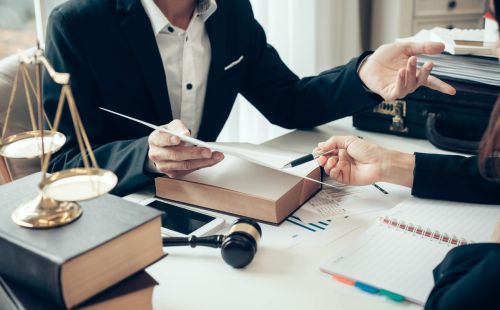 Close up of desk and documents as lawyer and client discuss - Pro bono attorney concept