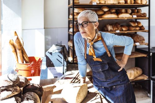 Shot of a senior woman looking unhappy while working behind the counter of a cafe - business owners divorce concept