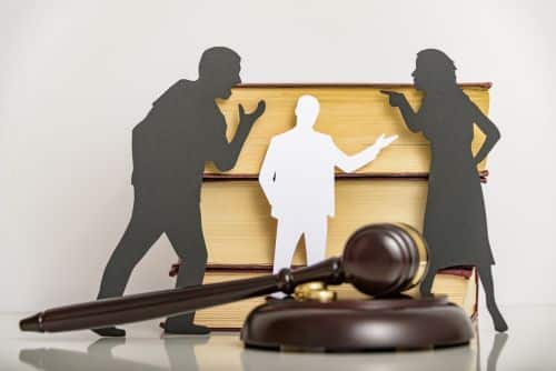 Silhouette symbol. wife and husband arguing in front of third party and gavel - mediation for high net worth divorces concept