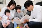 Young Asian family reading to children