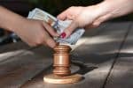 hands exchanging money over a gavel - negotiating child support concept
