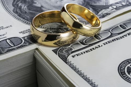 Wedding rings and stack of money - high asset divorce attorney concept